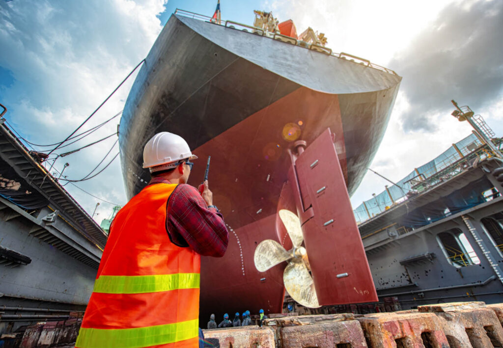 An engineer inspecting a vessel propeller in dry dock